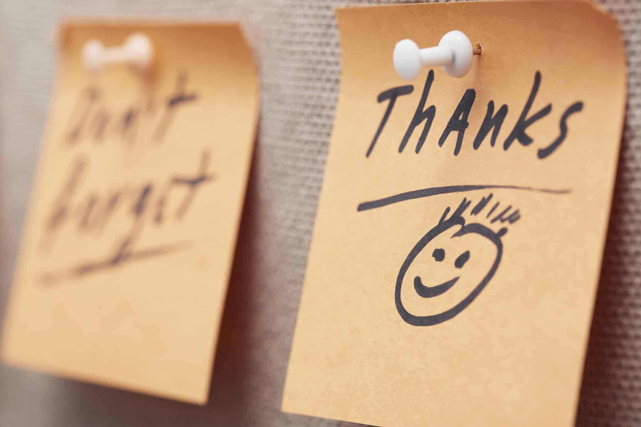two post its, one says don't forget, one says thanks with happy face, gratitude workplace plan