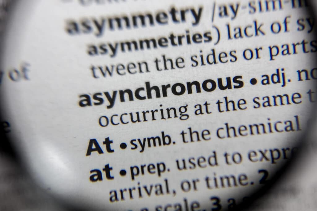 Asynchronous communication, magnifying glass on dictionary showing definition of asynchronous